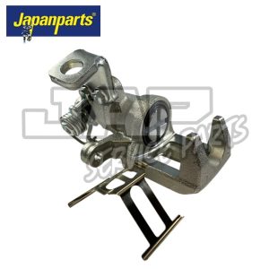 A metallic automotive part, possibly a brake calliper, with a spring and mounting bracket, is displayed on a white background. The Japanparts logo appears in the top left corner. | Jap Service Parts - Car Parts