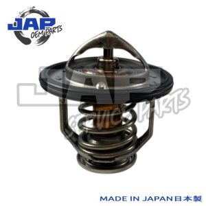 A metal automotive thermostat with a spring and rubber gasket, displayed upright on a white background. JAP OEM PARTS logo at the top left and MADE IN JAPAN 日本製 text at the bottom right. | Jap Service Parts - Car Parts