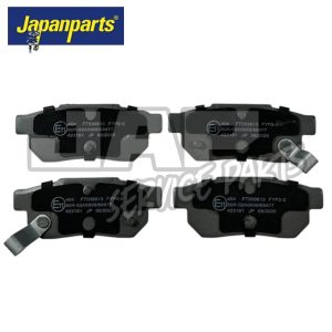 Four black Japanparts brake pads with silver metal tabs are arranged in two rows against a white background, with visible part numbers and certification markings on each pad. | Jap Service Parts - Car Parts