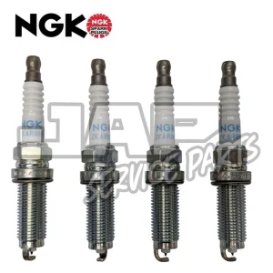Four NGK spark plugs are shown upright in a row with the NGK logo in the top left corner. The spark plugs have metallic bases and white ceramic insulators marked with blue text. | Jap Service Parts - Car Parts